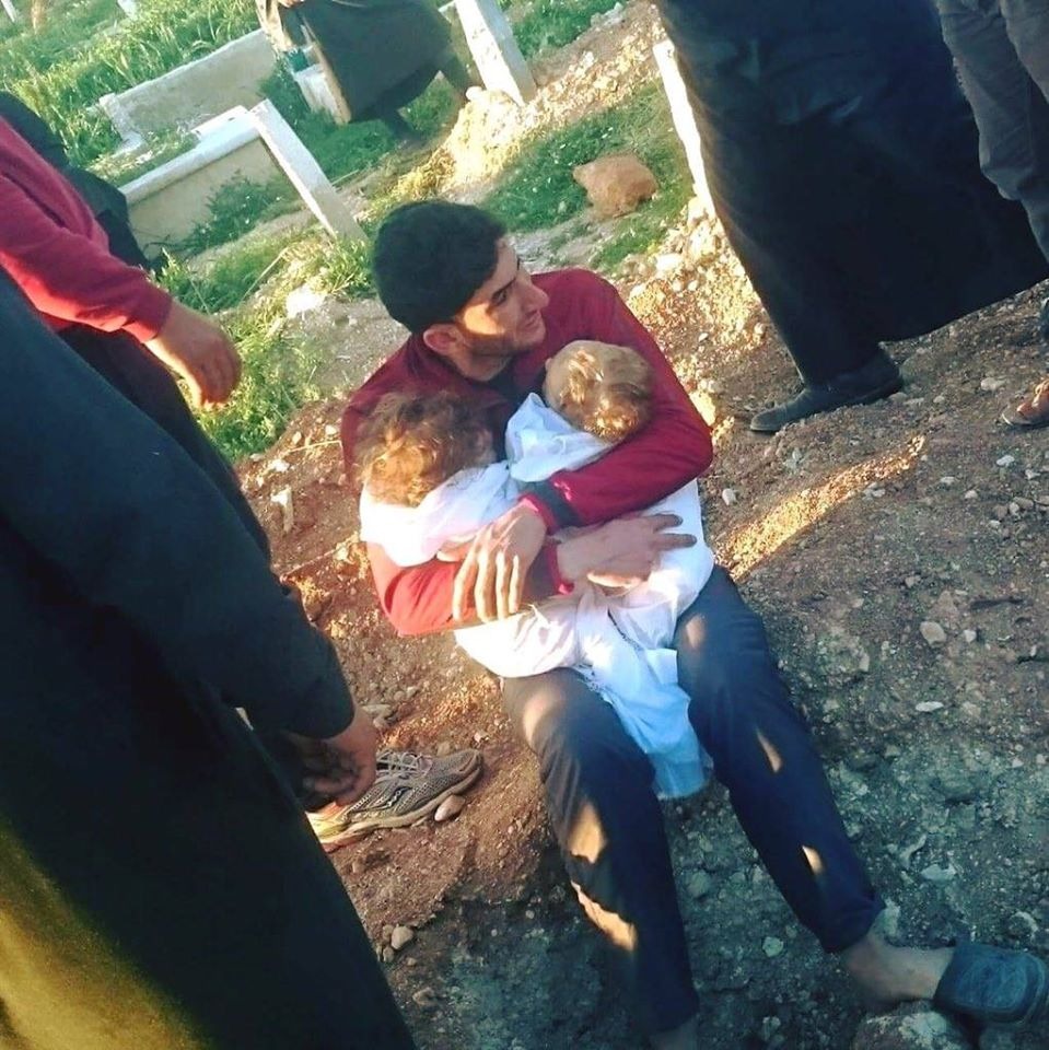 عبد الحميد اليوسف مع أطفاله التوأم بعد وفاتهما في مجزرة خان شيخون-انترنت