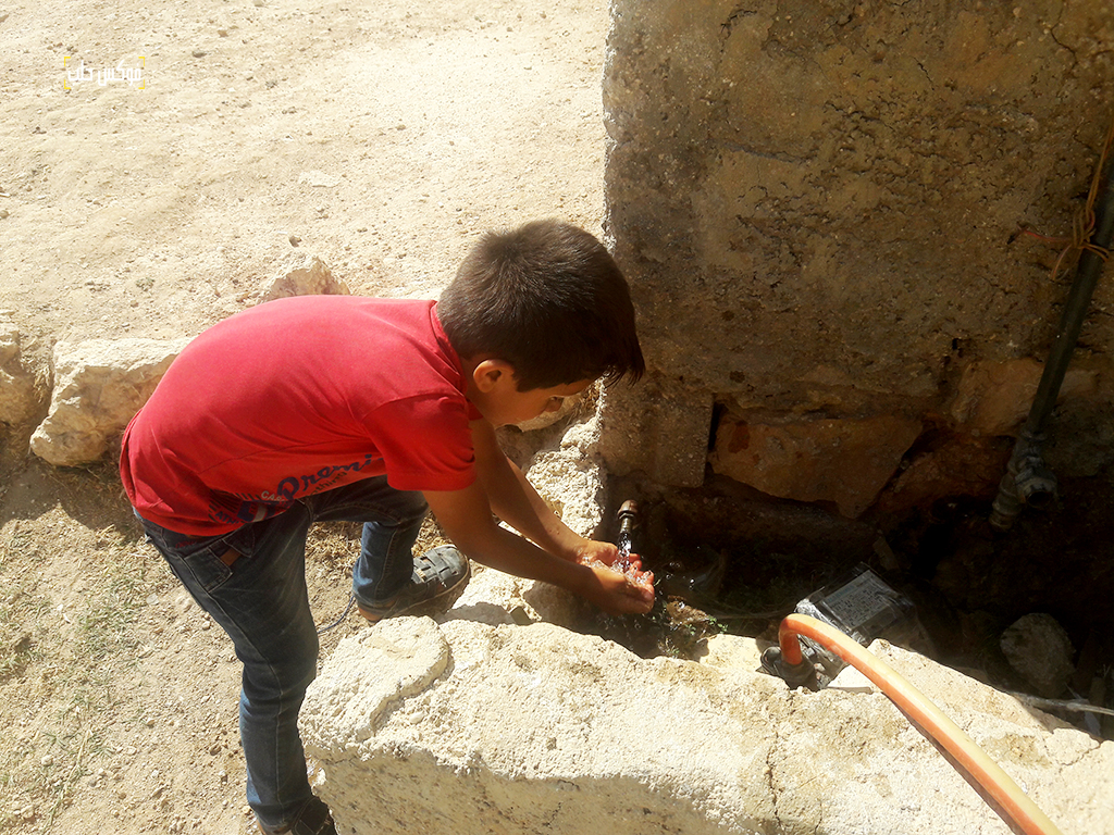 طفل في قرية تركمان بارح يشرب من منهل المياه العام مباشرة