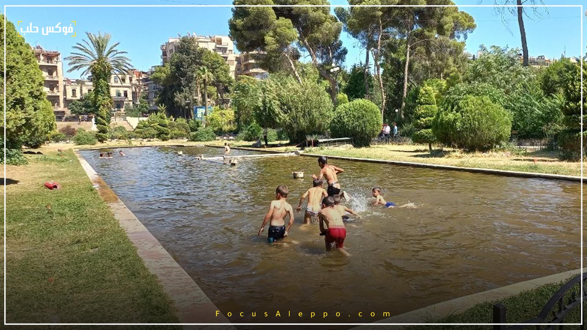 الصورة لأطفال يسبحون في بحرة داخل الحديقة العامة بحلب.