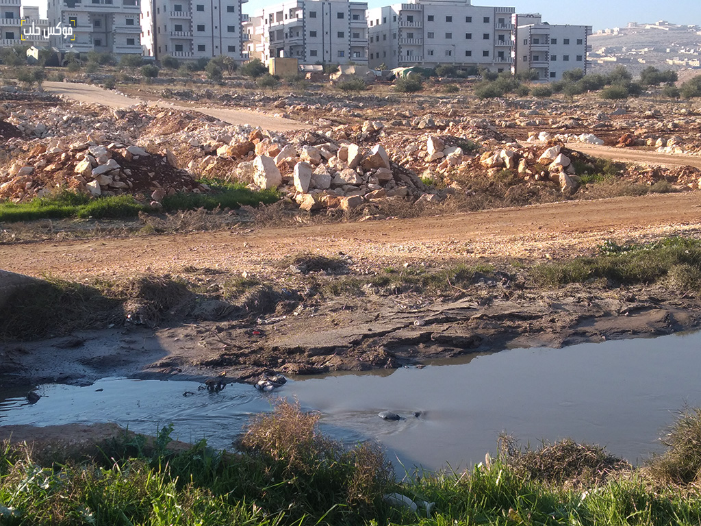 جزء من القسم المكشوف من مجرى الصرف الصحي في مدينة سرمدا بالقرب من ضاحية الشهباء 
