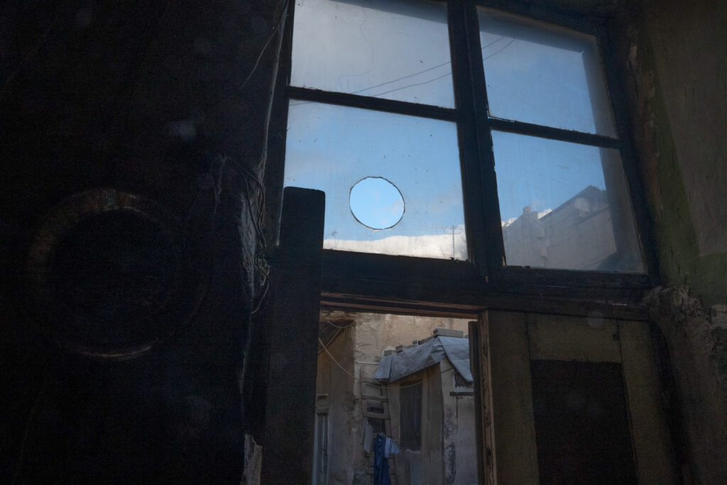 باب بيت الكاتبة حسيبة عبد الرحمن المفتوح دوماً للأصدقاء والنافذة المطلة على سرب حمام قريب، نيسان 2025- تصوير: رؤى القصير