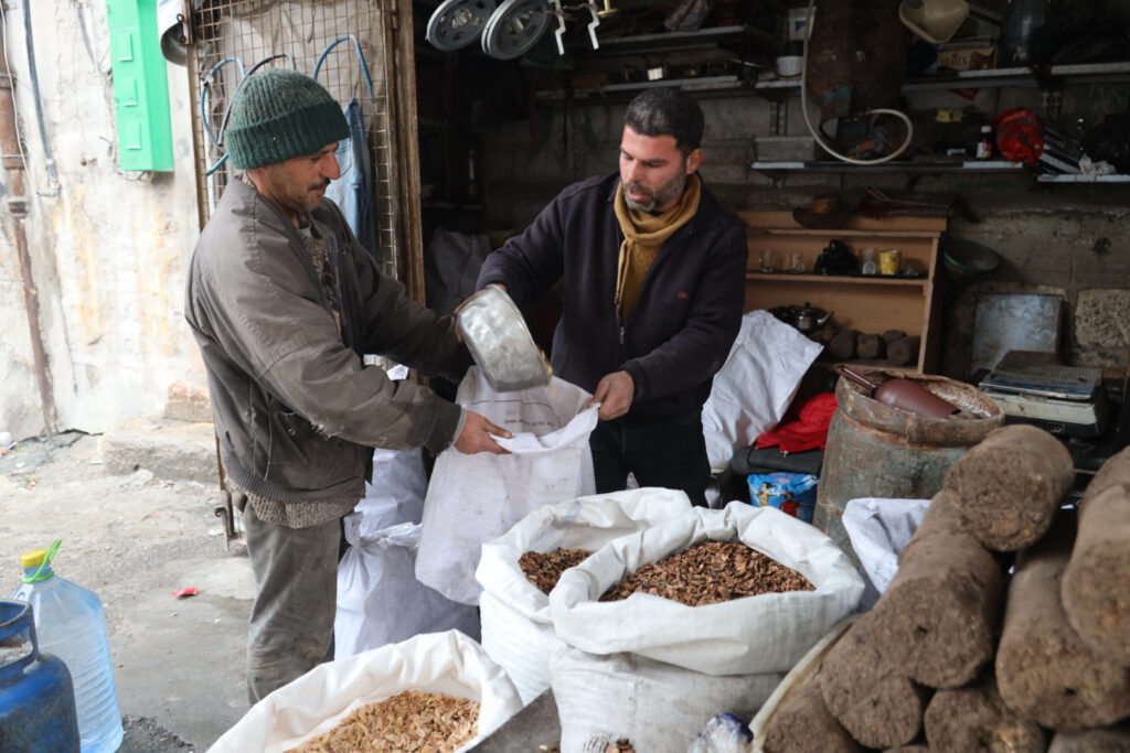 أحد بائعي مواد التدفئة يبيع قشر الفستق الحلبي، مدينة كفرتخاريم غربي إدلب، شباط 2025- تصوير: رهام علي.