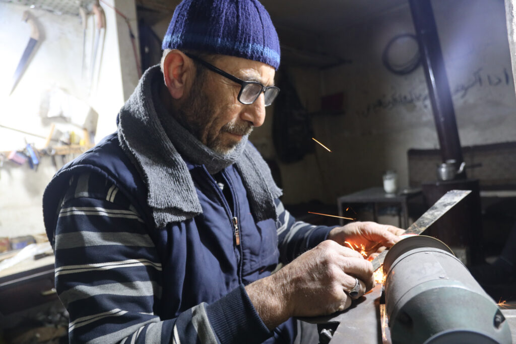 عبد المجيد قرقجية، أبو نذير، يصنع منشارًا يدويًا، مدينة كفرتخاريم غربي ادلب، شباط 2025- تصوير: رهام علي.
 
