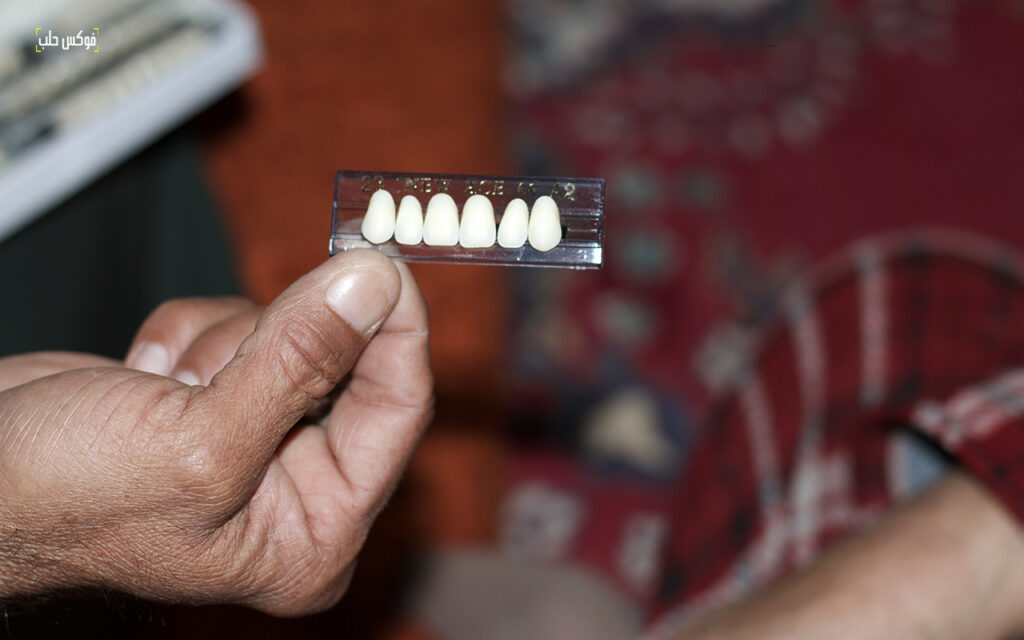 مجموعة أسنان يعمل أبو حبيب في تركيبها للزبائن، أيار 2025.
