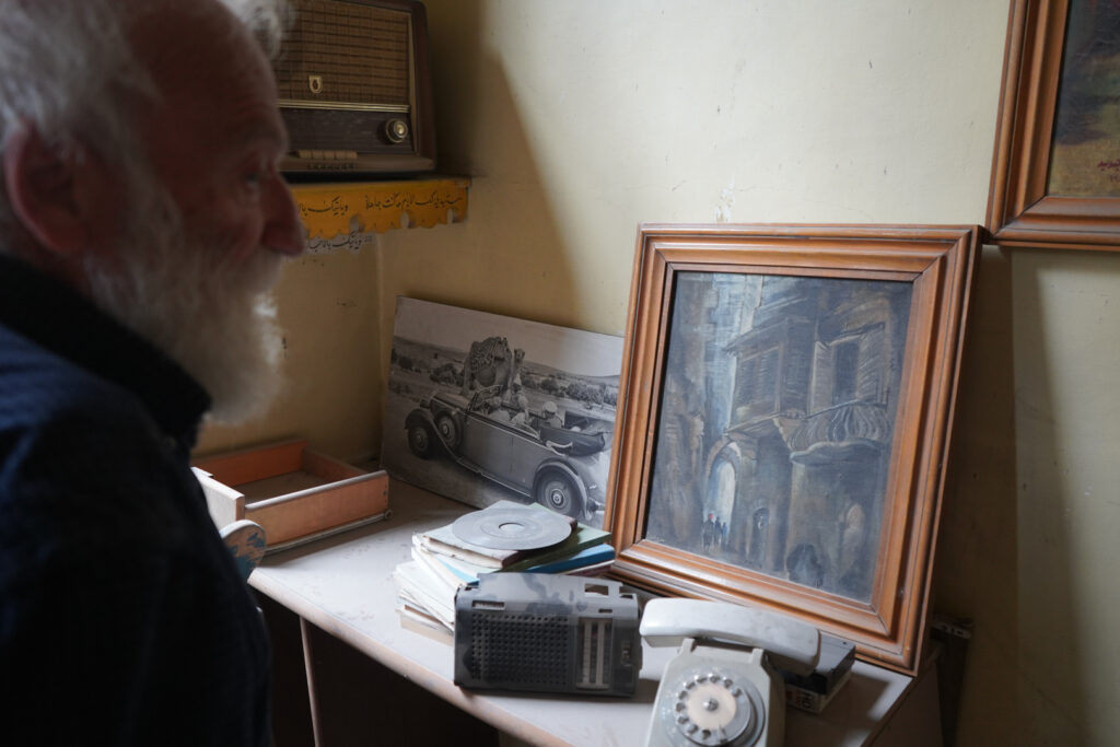 لوحة وهاتف منزلي ومقتنيات قديمة يحتفظ بها أبو عمر ويرفض بيعها، حي الشعار في مدينة حلب، 2025- تصوير: سحر زعتور.