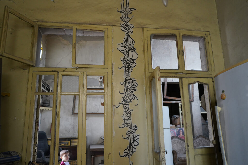 كتابة بالخطّ العربي داخل منزل أبي عمر، حي الشعار في مدينة حلب، 2025- تصوير: سحر زعتور.