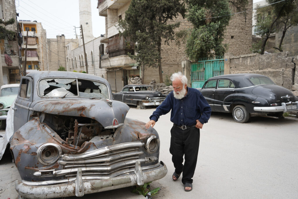 أبو عمر يتفقد سيارة والده التي يسميها الطربوش، حي الشعار في مدينة حلب، 2025- تصوير: سحر زعتور.