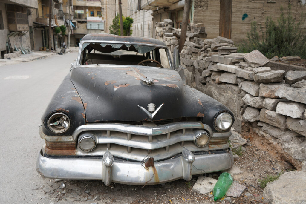 سيارة الكاديلاك تظهر عليها آثار التكسير والتخريب، حي الشعار في مدينة حلب، 2025- تصوير: سحر زعتور.