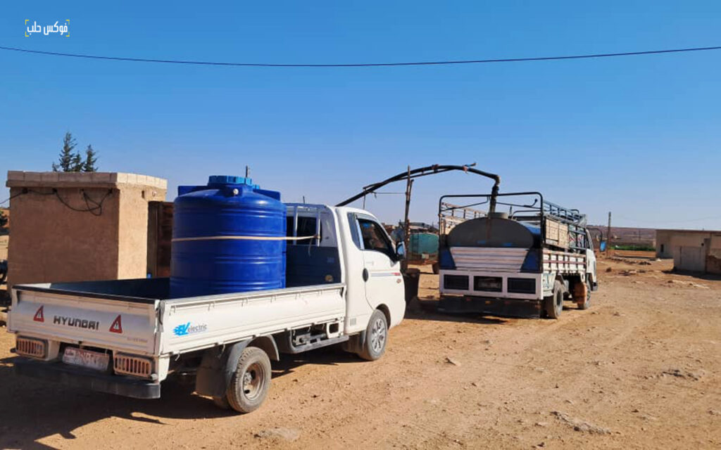 تعبئة خزانات من منهل ماء في قريب ابو غتة بريف حلب الجنوبي، حزيران 2025.