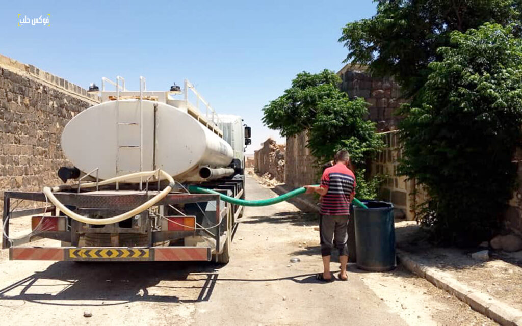 تبعئة مياه من صهريج في ناحية خناصر بريف حلب الجنوبي، حزيران 2025.