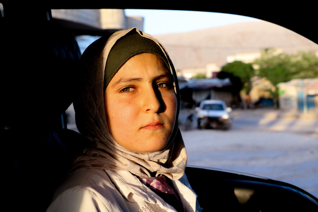  حُلوم تقود سيارة البورتر بعد عودتها من العمل. قرية مشمشان، جسر الشغور، أيار 2025- تصوير: هيام الباشا 
