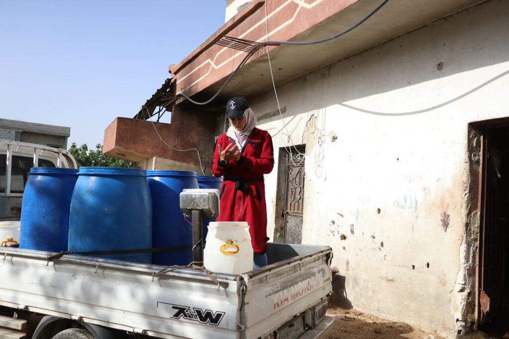 حلوم تسجل على كف يدها أوزان الحليب. قرية مشمشان، جسر الشغور، أيار 2025- تصوير: هيام الباشا
