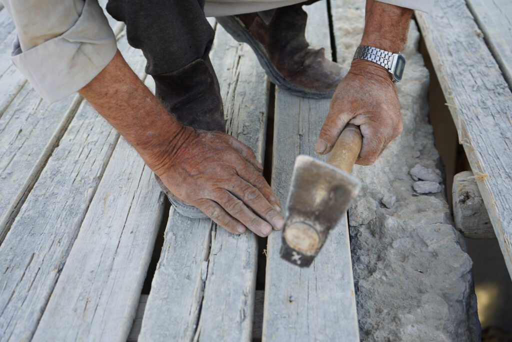 أبو محمد يثبت قالب الخشب بالمسامير استعدادًا لصب السقف، كفرنبل، ريف إدلب، أيار 2025- تصوير: سحر زعتور
