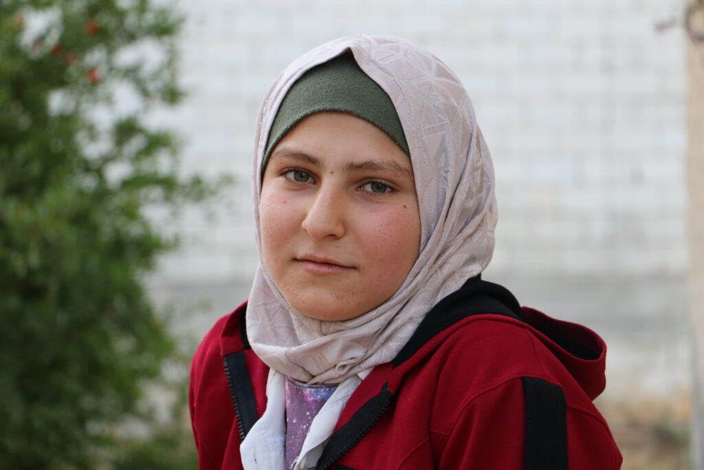 ابتسامة حلوم بعد عودتها من العمل. قرية مشمشان، جسر الشغور، أيار 2025- تصوير: هيام الباشا

