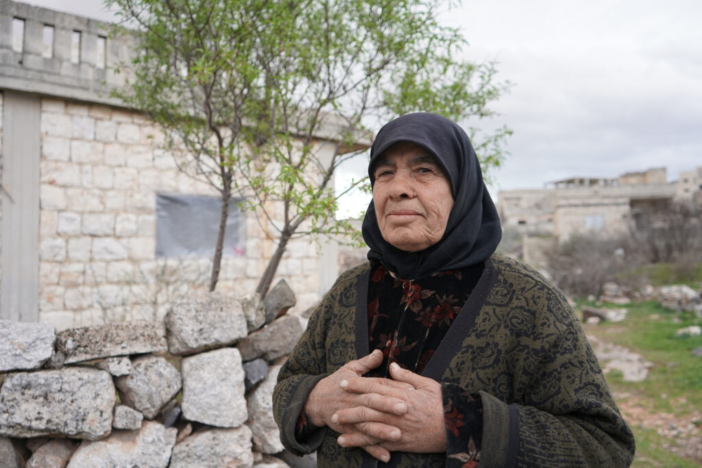  كعادتها كل يوم أم محمد تتجول حول المنزل بعد انتهائها من العمل، كفرنبل، ريف إدلب، أيار 2025- تصوير: سحر زعتور