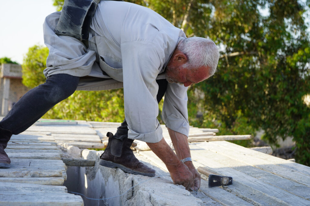 أبو محمد يجهز قالبَ صبّ الأسقف لترميم سقف أحد البيوت، 
كفرنبل، ريف إدلب، أيار 2025- تصوير: سحر زعتور

