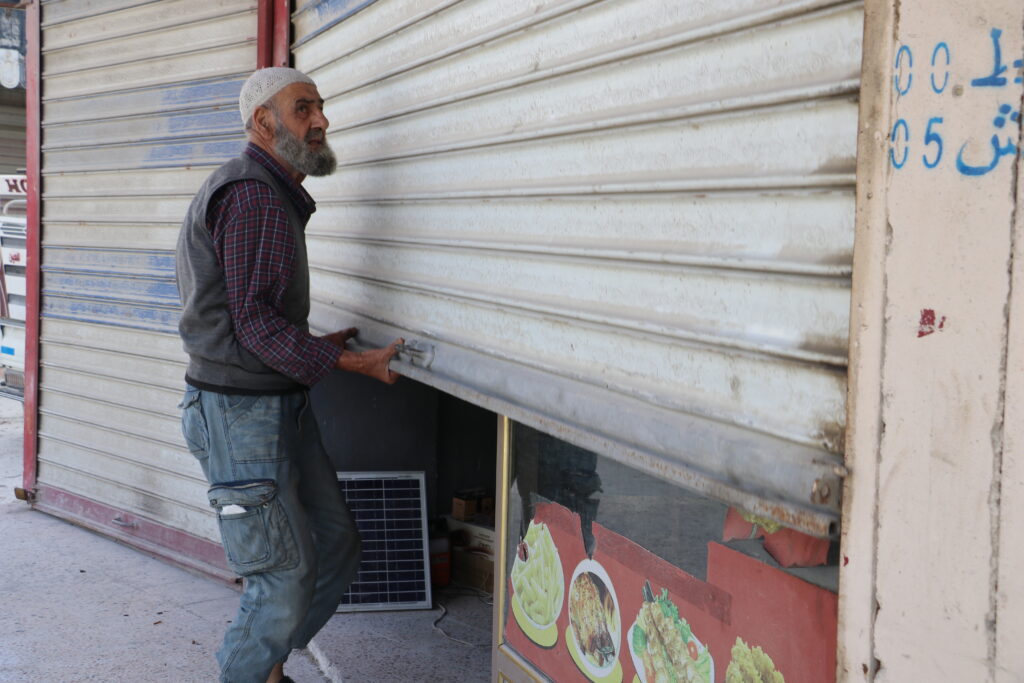 أبو محمود يفتح محله لبدء العمل. خربة الجوز، ريف جسر الشغور، تشرين الأول 2025. تصوير: هيام الباشا