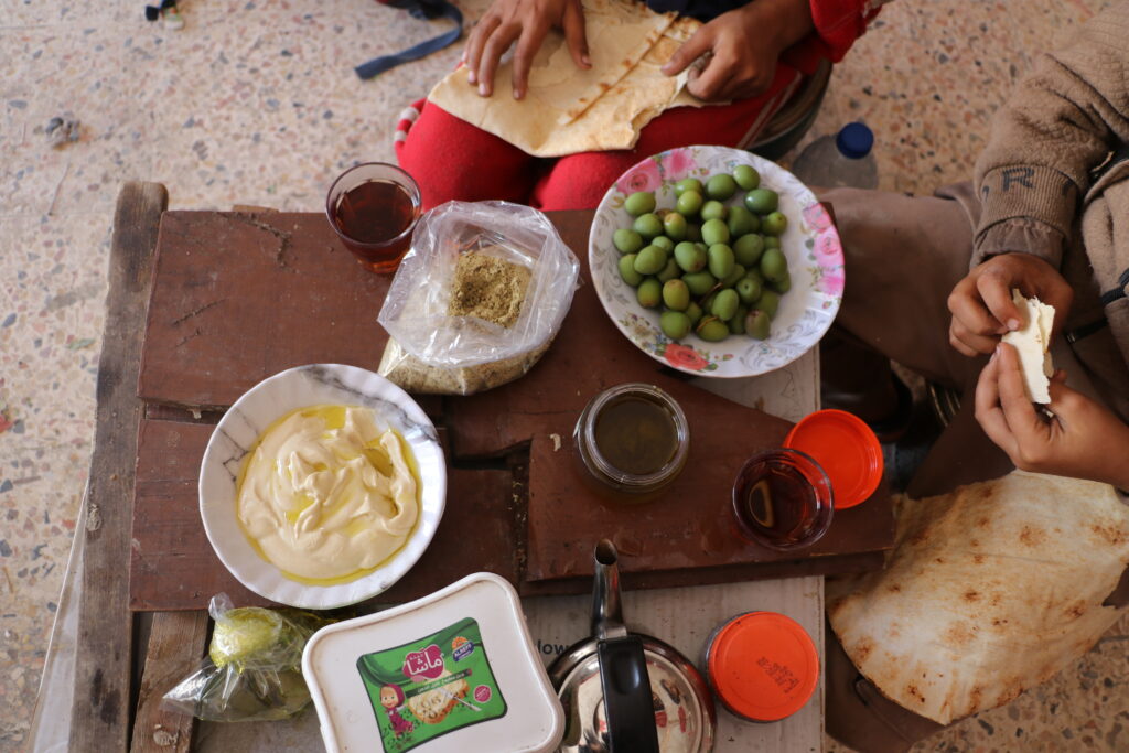 طعام لميس ومحمد في محل جدهما. خربة الجوز، ريف جسر الشغور. تشرين الأول 2025. تصوير: هيام الباشا