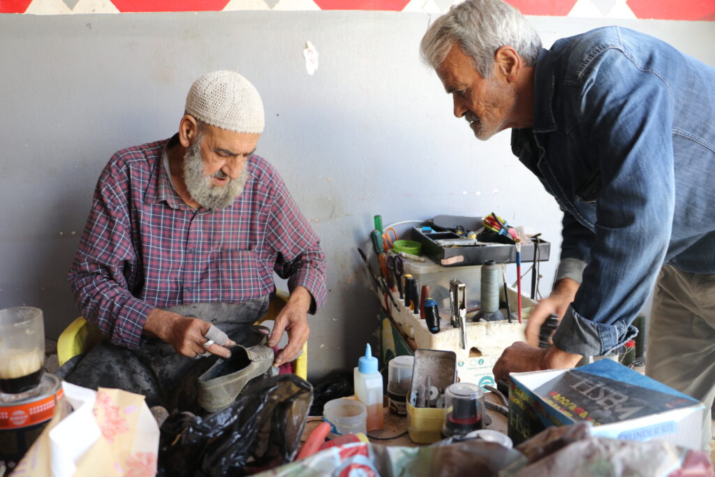  أبو محمود يستلم أحذية من زبائنه. خربة الجوز، ريف جسر الشغور، تشرين الأول 2025. تصوير: هيام الباشا