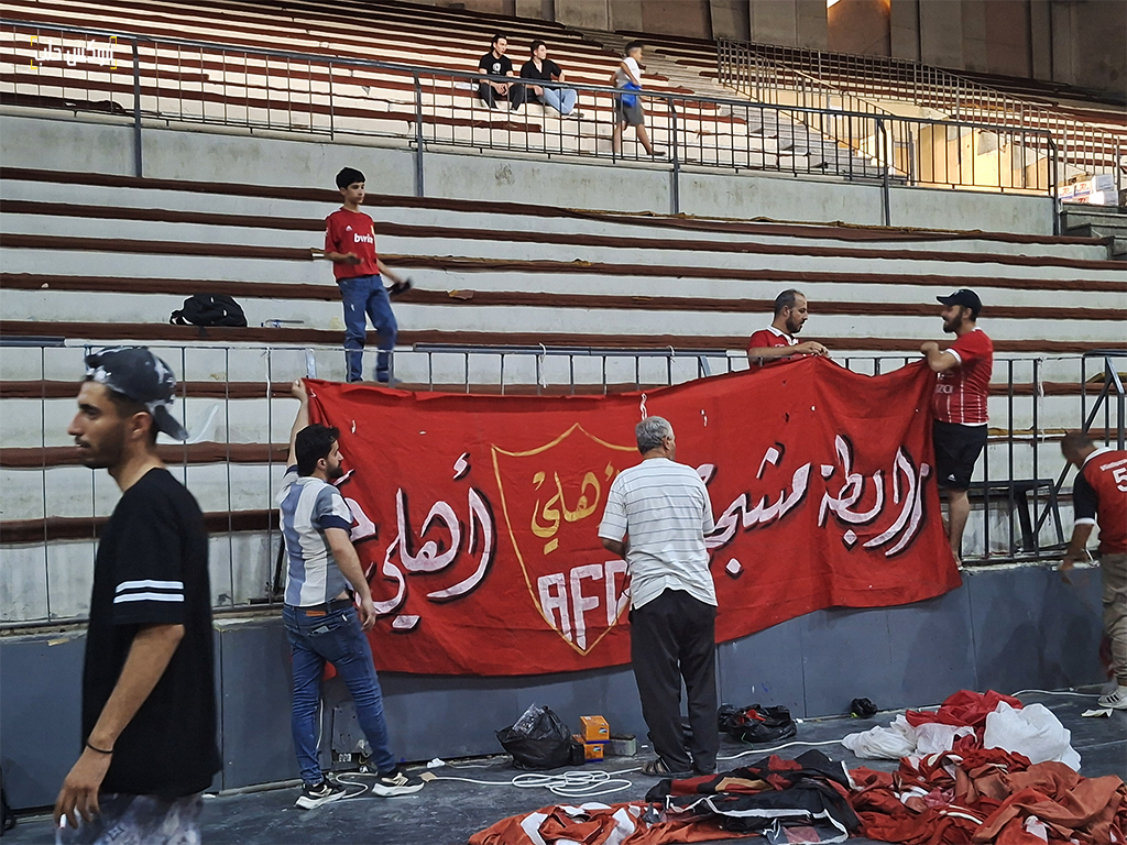 تجهيز المدرج باللافتات في صالة الشهباء استعدادا لمباراة الأهلي والوحدة
